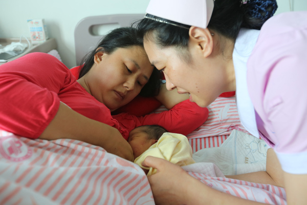 A nurse at a hospital in Xiangyang, Hubei province, helps Chen Jing to breast-feed her second child on Friday.(Photo by Gong Bo / Provide to China Daily) A nurse at a hospital in Xiangyang, Hubei province, helps Chen Jing to breast-feed her second child on Friday.(Photo by Gong Bo / Provide to China Daily)