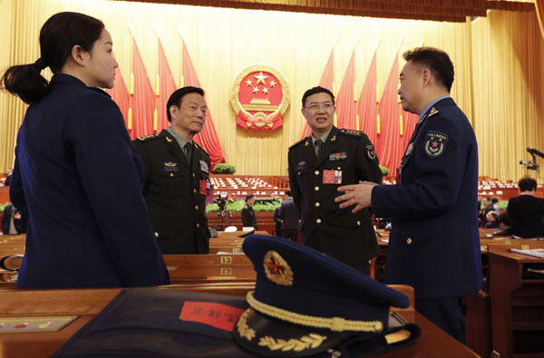 National People's Congress deputies from the People's Liberation Army chat ahead of the third plenary session of the NPC annual session in Beijing on Sunday. XU JINGXING/CHINA DAILY National People's Congress deputies from the People's Liberation Army chat ahead of the third plenary session of the NPC annual session in Beijing on Sunday. XU JINGXING/CHINA DAILY