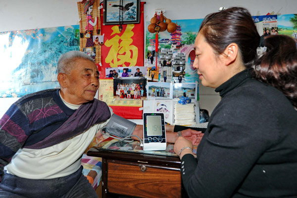 A social worker checks an old man's blood pressure at a residential community in Changchun, Northeast China's Jilin province. (Photo/Xinhua) A social worker checks an old man's blood pressure at a residential community in Changchun, Northeast China's Jilin province. (Photo/Xinhua)