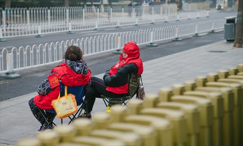 Two women wearing red armbands chat as they keep an eye on a street in Beijing. (Photo: Li Hao/GT) Two women wearing red armbands chat as they keep an eye on a street in Beijing. (Photo: Li Hao/GT)