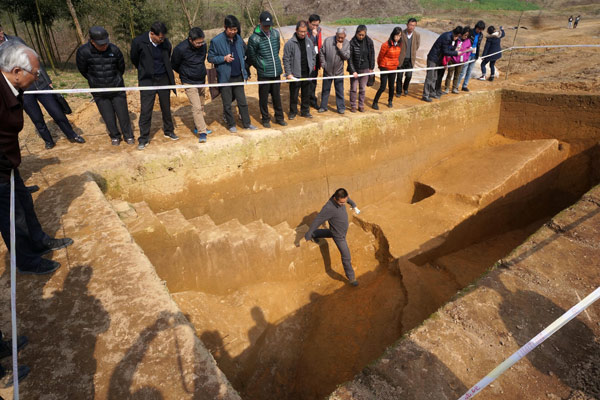 An archaeologist examines sections of unearthed ancient flood-control dams in Hangzhou, Zhejiang province. Wu Huang/for China Daily An archaeologist examines sections of unearthed ancient flood-control dams in Hangzhou, Zhejiang province. Wu Huang/for China Daily