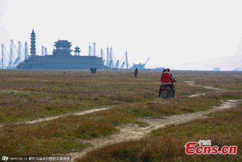 An island stands in Poyang Lake after water level declines in Xingzi county, Jiujiang city, East China’s Jiangxi province, Jan 3, 2015. Due to persistent drought and less runoff from the upstream, the county’s landmark is now accessible by walking, rather than a boat during the wet season. (Photo/CFP) An island stands in Poyang Lake after water level declines in Xingzi county, Jiujiang city, East China’s Jiangxi province, Jan 3, 2015. Due to persistent drought and less runoff from the upstream, the county’s landmark is now accessible by walking, rather than a boat during the wet season. (Photo/CFP)