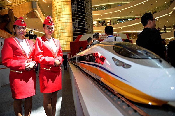 Two women stand by the model of a bullet train manufactured by China Railway Rolling Stock Corp at a fair in Jakarta, Indonesia. (Photo/Xinhua) Two women stand by the model of a bullet train manufactured by China Railway Rolling Stock Corp at a fair in Jakarta, Indonesia. (Photo/Xinhua)