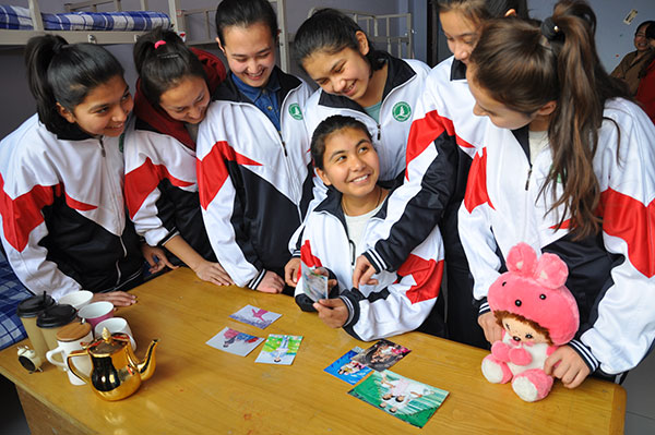 Students from the Xinjiang Uygur autonomous region look at photographs in their dormitory at Rizhao Experimental High School in Shandong province. A total of 49 Xinjiang students, including 19 from different ethnic groups, have studied at the school since October 2014. LIU MINGZHAO/CHINA DAILY Students from the Xinjiang Uygur autonomous region look at photographs in their dormitory at Rizhao Experimental High School in Shandong province. A total of 49 Xinjiang students, including 19 from different ethnic groups, have studied at the school since October 2014. LIU MINGZHAO/CHINA DAILY