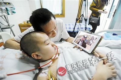 Cheng Jun shows Ruirui photos of happy past events on a tablet PC. (Photo/Chongqing Evening News) Cheng Jun shows Ruirui photos of happy past events on a tablet PC. (Photo/Chongqing Evening News)