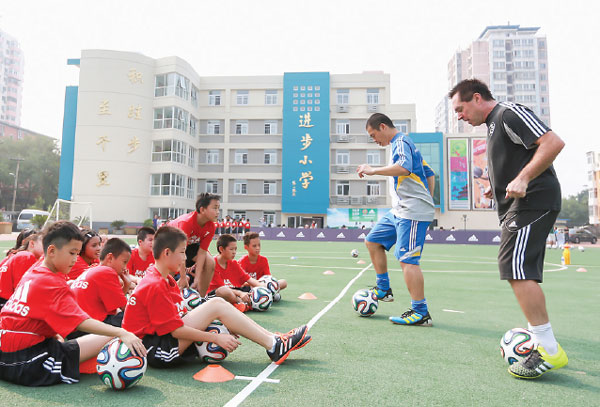 Tom Byer (right), an international soccer coach, teaches primary school pupils in Beijing. (Photo provided to China Daily) Tom Byer (right), an international soccer coach, teaches primary school pupils in Beijing. (Photo provided to China Daily)