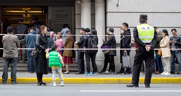 People in Shanghai wait in line on Sunday to buy bidding documents in the monthly auction to get local license plates for private vehicles.Zhu Weihui / For China Daily People in Shanghai wait in line on Sunday to buy bidding documents in the monthly auction to get local license plates for private vehicles.Zhu Weihui / For China Daily