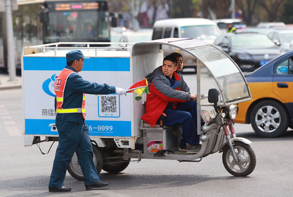 A traffic warden intercepts an electric tricycle in Beijing on April 11, 2016. The capital imposed a ban that bars electric bikes and tricycles from 10 roads, including Chang'an Avenue and some of its connecting roads. Drivers will be fined 20 yuan ($3.10) for using the roads, and their vehicles will be seized if they refuse to pay the fine. (Photo by Zou Hong/China Daily) A traffic warden intercepts an electric tricycle in Beijing on April 11, 2016. The capital imposed a ban that bars electric bikes and tricycles from 10 roads, including Chang'an Avenue and some of its connecting roads. Drivers will be fined 20 yuan ($3.10) for using the roads, and their vehicles will be seized if they refuse to pay the fine. (Photo by Zou Hong/China Daily)
