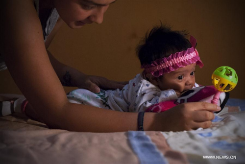 Image taken on Feb. 27, 2016 shows Angela Martinez, playing with her daughter Dominic Andrade (R), who suffers microcephaly, in Quito, capital of Ecuador. Dominic Andrade, 4 months old, permanently receives therapy at home and on the facilities of a hospital due to microcephaly that has affected her since birth. (Xinhua file photo/Santiago Armas) Image taken on Feb. 27, 2016 shows Angela Martinez, playing with her daughter Dominic Andrade (R), who suffers microcephaly, in Quito, capital of Ecuador. Dominic Andrade, 4 months old, permanently receives therapy at home and on the facilities of a hospital due to microcephaly that has affected her since birth. (Xinhua file photo/Santiago Armas)