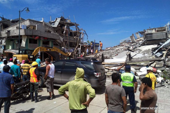 Residents stand in front of the debris of houses after an earthquake in the city of Chone, Manabi Province, Ecuador, on April 17, 2016.  (Xinhua/Jorge Penafiel/EL UNIVERSO)