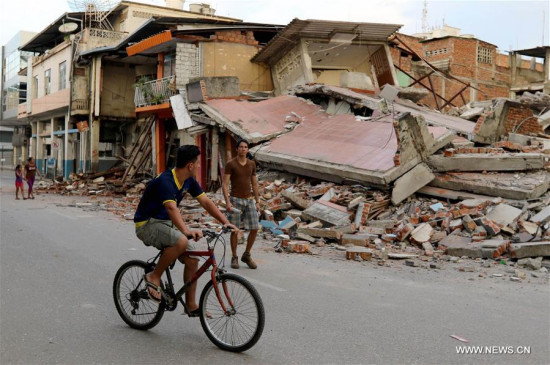 Image taken on April 18, 2016 provided by the Ecuadorian and South American Public News Agency ANDES shows people standing in front of a collapsed building by the earthquake, in Portoviejo, Ecuador. (Xinhua/Cesar Munoz/ANDES)