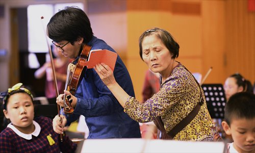 A grandmother records a violin teacher's performance so that her grandson can follow his example and practice at home. (Photo/Courtesy of Jin Siliu) A grandmother records a violin teacher's performance so that her grandson can follow his example and practice at home. (Photo/Courtesy of Jin Siliu)