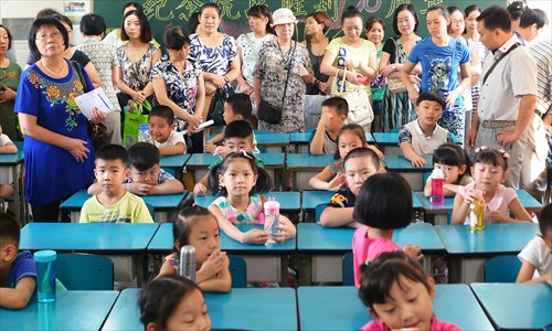 Many parents stand in the back of a first-grade classroom on the first day of school. They won't leave until the teacher asks them. (Photo/Courtesy of Jin Siliu) Many parents stand in the back of a first-grade classroom on the first day of school. They won't leave until the teacher asks them. (Photo/Courtesy of Jin Siliu)