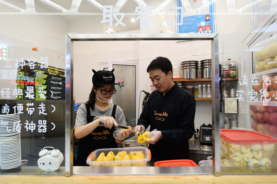 Cui Jianwei works with an employee at a shop in Taiyuan, Shanxi province, April 26, 2016. In order to keep flavors good, all of the ingredients in the ice cream are fresh, Cui said. (Photo/Xinhua) Cui Jianwei works with an employee at a shop in Taiyuan, Shanxi province, April 26, 2016. In order to keep flavors good, all of the ingredients in the ice cream are fresh, Cui said. (Photo/Xinhua)