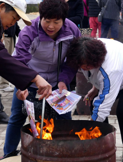People in Beijing burn symbolic paper money outside a cemetery park as offerings to their deceased relatives on April 2, 2016 during the Tomb Sweeping Day holiday. (Photo/China News Service) People in Beijing burn symbolic paper money outside a cemetery park as offerings to their deceased relatives on April 2, 2016 during the Tomb Sweeping Day holiday. (Photo/China News Service)