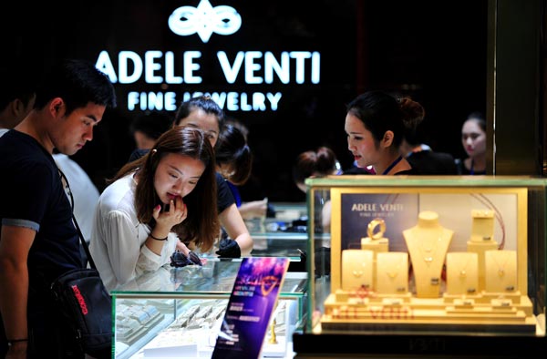 Tourists examine jewelry at a duty-free shop in Sanya, Hainan province. China's luxury market shrank slightly last year. (Photo/Xinhua) Tourists examine jewelry at a duty-free shop in Sanya, Hainan province. China's luxury market shrank slightly last year. (Photo/Xinhua)