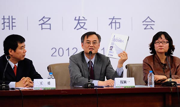 Qian Yingyi (center), dean and professor at the School of Economics and Management of Tsinghua University, holds a book about EMBA rating and development in China. SHEN YUBO / FOR CHINA DAILY Qian Yingyi (center), dean and professor at the School of Economics and Management of Tsinghua University, holds a book about EMBA rating and development in China. SHEN YUBO / FOR CHINA DAILY