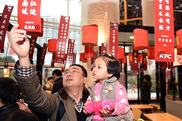 A father and his daughter take part in the riddle-guessing contest at a KFC outlet in Zhengzhou, capital of Henan province, during this year's Lantern Festival. SHA LANG /CHINA DAILY A father and his daughter take part in the riddle-guessing contest at a KFC outlet in Zhengzhou, capital of Henan province, during this year's Lantern Festival. SHA LANG /CHINA DAILY
