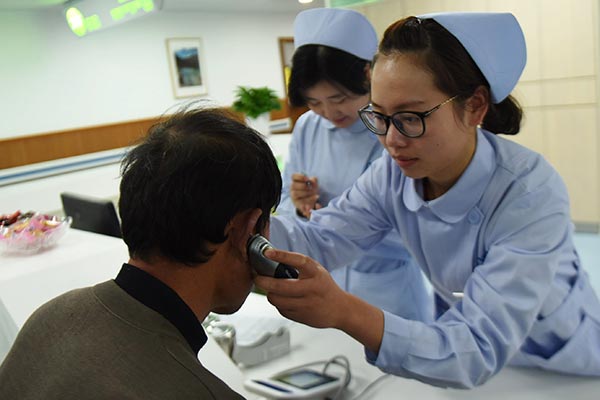 A nurse measures body temperature of patients at a medical center in Hangzhou, Zhejiang province. LONG WEI / FOR CHINA DAILY A nurse measures body temperature of patients at a medical center in Hangzhou, Zhejiang province. LONG WEI / FOR CHINA DAILY