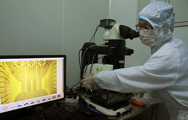 An engineer examines the microstructure of a biochip at the National Engineering Research Center for Beijing Biochip Technology in Beijing this month.Zou Hong / China Daily An engineer examines the microstructure of a biochip at the National Engineering Research Center for Beijing Biochip Technology in Beijing this month.Zou Hong / China Daily