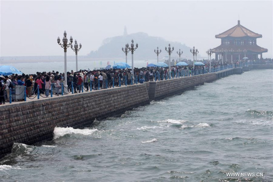 Tourists visit the Zhanqiao Pier in Qingdao, a coastal city in east China's Shandong Province, April 30, 2016. On the first day of the Labor Day Holiday, many tourists flocked to Qingdao. (Photo: Xinhua/Yin Mo)