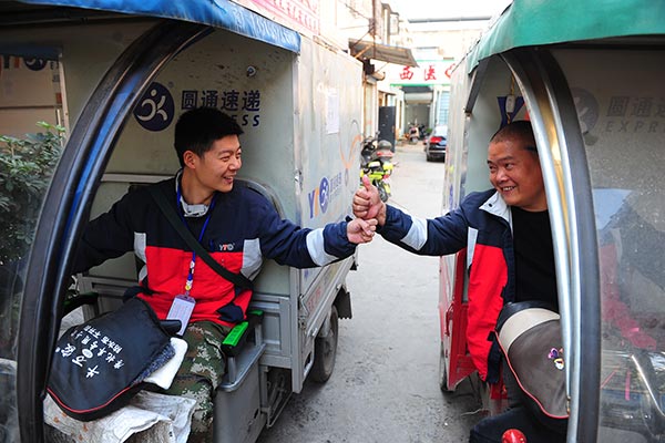Two YTO Express couriers cheer each other up before they go to work in Fuyang, Anhui province.(Photo: China Daily/Wang Biao) Two YTO Express couriers cheer each other up before they go to work in Fuyang, Anhui province.(Photo: China Daily/Wang Biao)