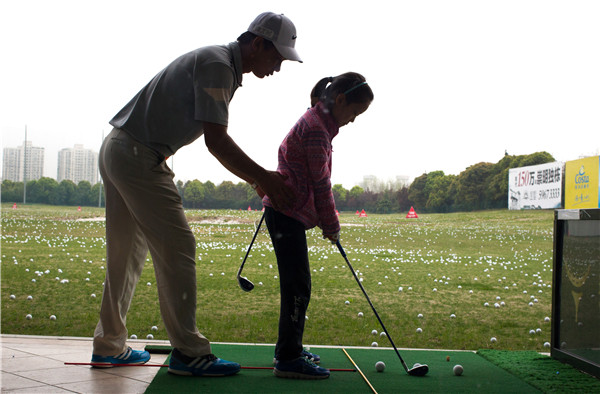 A girl practices under the guidance of a coach at the Yao Shine Golf School in Shanghai on April 9. A growing number of primary schools in the city have put the game on their curriculums as an option for PE lessons or as an afterschool activity.GAO ERQIANG/CHINA DAILY A girl practices under the guidance of a coach at the Yao Shine Golf School in Shanghai on April 9. A growing number of primary schools in the city have put the game on their curriculums as an option for PE lessons or as an afterschool activity.GAO ERQIANG/CHINA DAILY