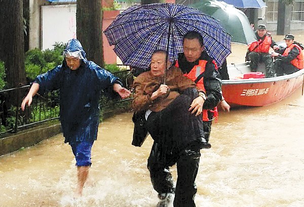 Armed Police Force officers help evacuate stranded local people in the wake of a massive landslide which trapped more than 40 people in Sanming, Fujian province, on Sunday. ZE XIN / FOR CHINA DAILY Armed Police Force officers help evacuate stranded local people in the wake of a massive landslide which trapped more than 40 people in Sanming, Fujian province, on Sunday. ZE XIN / FOR CHINA DAILY
