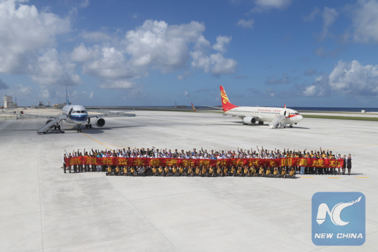 File photo: People pose for a group photo together after landing at the airfield on Yongshu Jiao in the Nansha Islands, Jan. 6, 2016. China successfully carried out test fights of two civilian aircraft on Jan. 6 on a newly-built airfield in the Nansha Islands of the South China Sea. (Xinhua file photo/Xing Guangli)