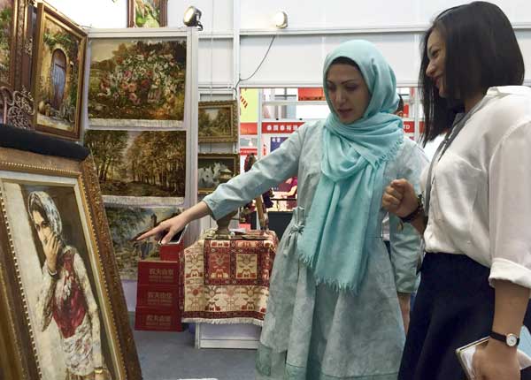 An Iranian cultural representative shows a tapestry to a Chinese buyer at the 12th China (Shenzhen) International Cultural Industries Fair, which opened Thursday in Shenzhen. (Photo by Qiu Quanlin/chinadaily.com.cn) An Iranian cultural representative shows a tapestry to a Chinese buyer at the 12th China (Shenzhen) International Cultural Industries Fair, which opened Thursday in Shenzhen. (Photo by Qiu Quanlin/chinadaily.com.cn)