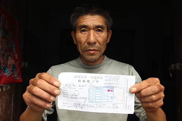 Yang Shoufa holds the diagnosis that said he was HIV negative. (Photo/People's Daily Online) Yang Shoufa holds the diagnosis that said he was HIV negative. (Photo/People's Daily Online)