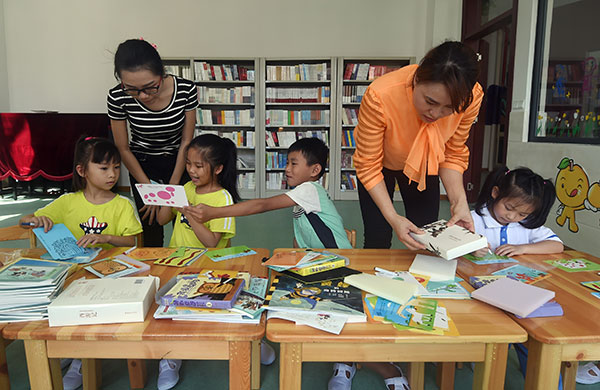 Teachers encourage students in a reading class at Yongxing School, Yongxing Island, where Sansha city is located. YANG GUANYU/XINHUA Teachers encourage students in a reading class at Yongxing School, Yongxing Island, where Sansha city is located. YANG GUANYU/XINHUA