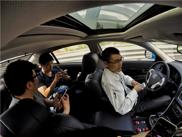 Engineers watch videos on their smartphones during a test journey from Chongqing in southwestern China to Beijing in April. The car used was an autonomous sedan developed by Chang'an Automobile Group.CUI LI/CHINA DAILY Engineers watch videos on their smartphones during a test journey from Chongqing in southwestern China to Beijing in April. The car used was an autonomous sedan developed by Chang'an Automobile Group.CUI LI/CHINA DAILY