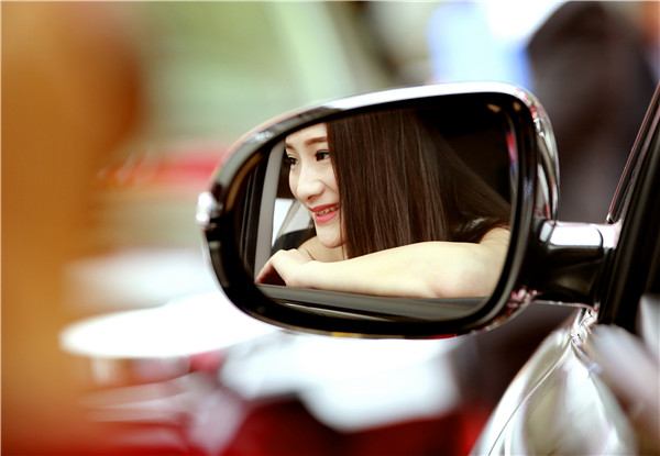 A woman checks a new model's mirror during a recent auto fair in Yichang, Hubei province. The MPV segment has been growing rapidly in the past three years.LIU JIAO/CHINA DAILY A woman checks a new model's mirror during a recent auto fair in Yichang, Hubei province. The MPV segment has been growing rapidly in the past three years.LIU JIAO/CHINA DAILY