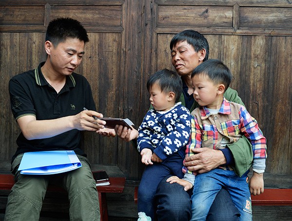 Song Minghong (left), a government employee in Huarong village, Hunan province, records information about Duan Zeben's grandsons for the country's first national survey of left-behind children. LIU JIE/XINHUA/ZHU WENBIAO/CHINA DAILY Song Minghong (left), a government employee in Huarong village, Hunan province, records information about Duan Zeben's grandsons for the country's first national survey of left-behind children. LIU JIE/XINHUA/ZHU WENBIAO/CHINA DAILY