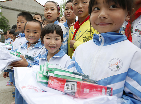 The children of migrant workers in Hujia village, Jiangxi province, receive gifts in advance of Children's Day, which falls on June 1. LIU JIE/XINHUA/ZHU WENBIAO/CHINA DAILY The children of migrant workers in Hujia village, Jiangxi province, receive gifts in advance of Children's Day, which falls on June 1. LIU JIE/XINHUA/ZHU WENBIAO/CHINA DAILY