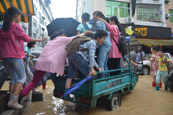 People climb onto a motorized tricycle to get around after heavy rain in Ningde, Fujian province, on June 2, 2016. (Photo/China News Service) People climb onto a motorized tricycle to get around after heavy rain in Ningde, Fujian province, on June 2, 2016. (Photo/China News Service)