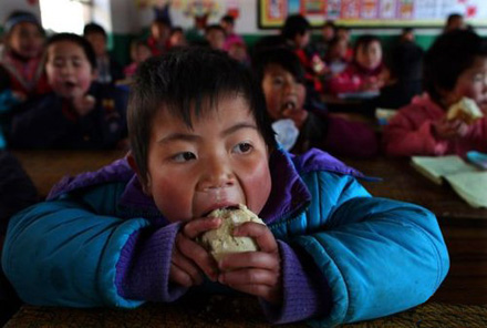 A boy eats cold steamed buns at school in Xiji county, Ningxia on Feb. 23, 2011. (File photo/Xinhua) A boy eats cold steamed buns at school in Xiji county, Ningxia on Feb. 23, 2011. (File photo/Xinhua)