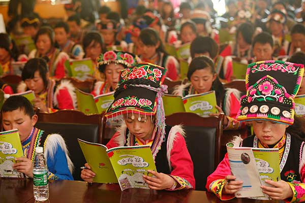 Students from the Qiang ethnic group study the regional textbook in Sichuan province. CHINA DAILY Students from the Qiang ethnic group study the regional textbook in Sichuan province. CHINA DAILY