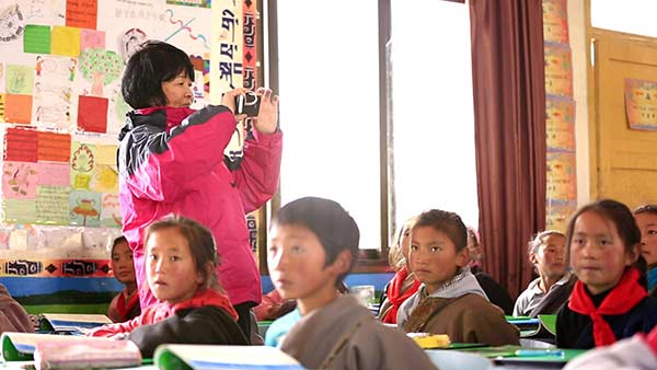 Wang Xiaoping visits a school, which uses a textbook compiled by her project, in Sichuan province. CHINA DAILY Wang Xiaoping visits a school, which uses a textbook compiled by her project, in Sichuan province. CHINA DAILY