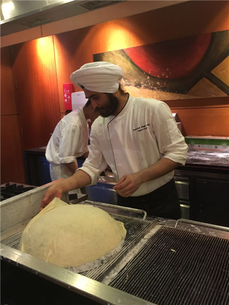 The handkerchief bread is folded on top of a 350 Celsius degree hot pan. (Photo by Jiang Wanjuan/chinadaily.com.cn) The handkerchief bread is folded on top of a 350 Celsius degree hot pan. (Photo by Jiang Wanjuan/chinadaily.com.cn)