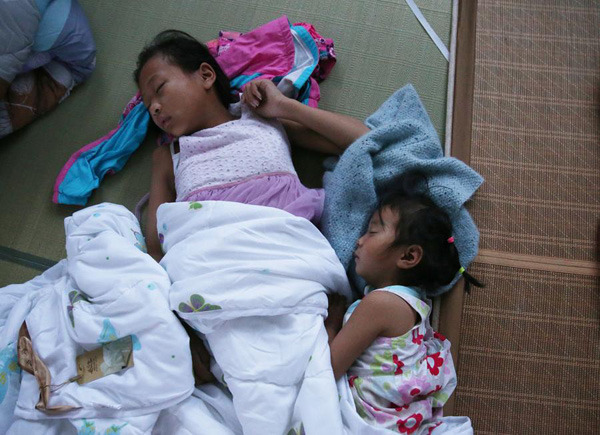 Two girls sleep at a temporary settlement in a primary school of Shuoji town, Funing county in Yancheng, Jiangsu province, on June 24, 2016. (Photo/Xinhua) Two girls sleep at a temporary settlement in a primary school of Shuoji town, Funing county in Yancheng, Jiangsu province, on June 24, 2016. (Photo/Xinhua)