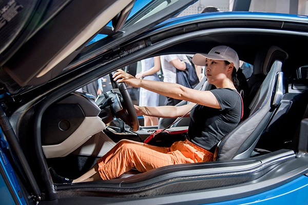 A woman checks out a BMW electric car during a recent NEV fair in Nanjing. Some makers of electric cars have cooperated with property developers to install charging stations at residential areas and office buildings. (Photo provided to China Daily) A woman checks out a BMW electric car during a recent NEV fair in Nanjing. Some makers of electric cars have cooperated with property developers to install charging stations at residential areas and office buildings. (Photo provided to China Daily)