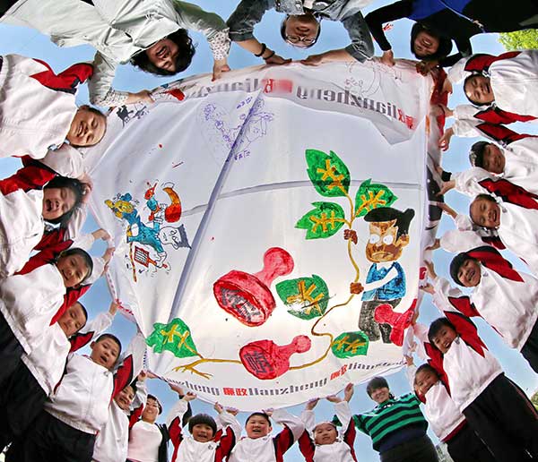 Primary school students and officials in Qinhuangdao, Hebei province, display a painting during an activity in May to promote clean politics and the fight against corruption. Cao Jianxiong / For China Daily Primary school students and officials in Qinhuangdao, Hebei province, display a painting during an activity in May to promote clean politics and the fight against corruption. Cao Jianxiong / For China Daily