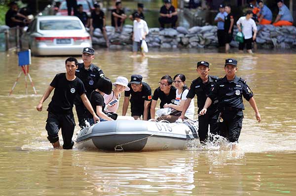 Police officers help residents in Nanjing, Jiangsu province, to use a rubber dinghy after some areas were flooded on Thursday.(Cui Xiao / For China Daily) Police officers help residents in Nanjing, Jiangsu province, to use a rubber dinghy after some areas were flooded on Thursday.(Cui Xiao / For China Daily)