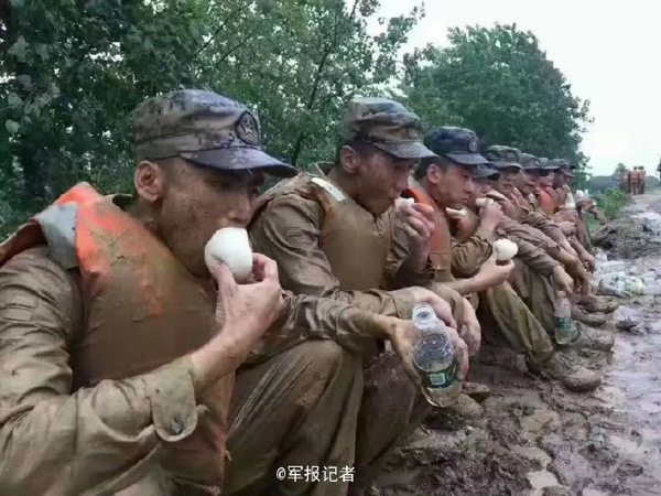 Xie Yongfu, a PLA soldier, eats a steamed bun during the flood relief work in Hubei province, on July 4, 2016. (Photo/Weibo) Xie Yongfu, a PLA soldier, eats a steamed bun during the flood relief work in Hubei province, on July 4, 2016. (Photo/Weibo)