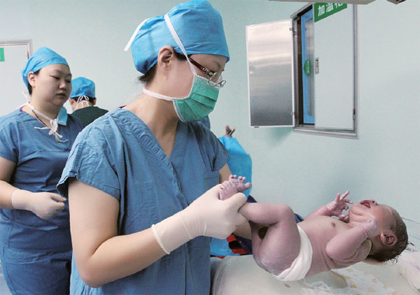 Medical staff check a newborn baby at Tangdu Hospital in Xi'an, Shaanxi province, in February. The boy was born from an embryo frozen 12 years ago, a record for the Chinese mainland. Ruan Banhui / For China Daily Medical staff check a newborn baby at Tangdu Hospital in Xi'an, Shaanxi province, in February. The boy was born from an embryo frozen 12 years ago, a record for the Chinese mainland. Ruan Banhui / For China Daily