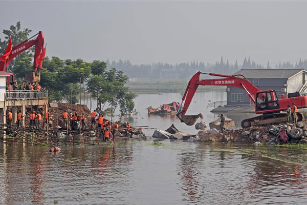 Excavators work at the plugged dike breach in Huarong County, central China's Hunan Province, July 12, 2016. The dike breach in Huarong was plugged after two days of rescue work. (Photo/Xinhua) Excavators work at the plugged dike breach in Huarong County, central China's Hunan Province, July 12, 2016. The dike breach in Huarong was plugged after two days of rescue work. (Photo/Xinhua)
