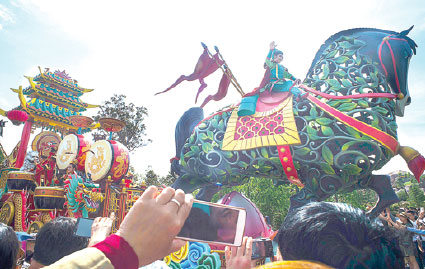 Visitors take pictures using mobile phones while a performer dressed as a Chinese traditional nomadic hero joins a parade of floats at Shanghai Disney Resort. (Provided to China Daily) Visitors take pictures using mobile phones while a performer dressed as a Chinese traditional nomadic hero joins a parade of floats at Shanghai Disney Resort. (Provided to China Daily)