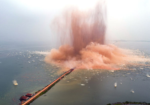 The dike that turned Liangzi Lake into two lakes 37 years ago is destroyed in a controlled explosion in Wuhan, Hubei province, on Thursday. HU JIUSI/CHINA DAILY The dike that turned Liangzi Lake into two lakes 37 years ago is destroyed in a controlled explosion in Wuhan, Hubei province, on Thursday. HU JIUSI/CHINA DAILY